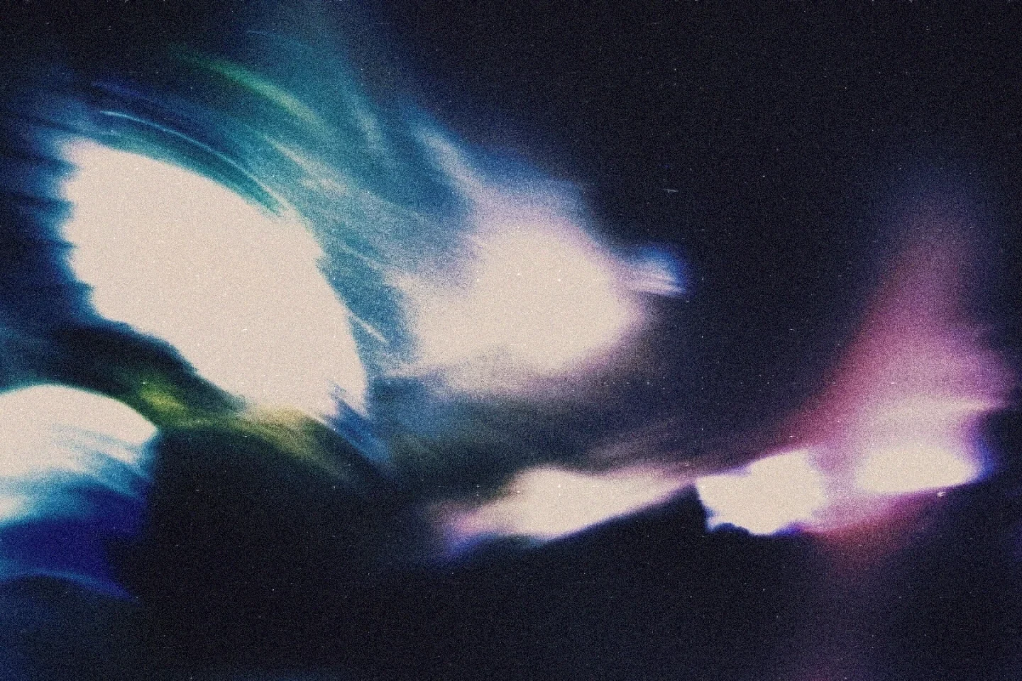 A blurred, almost human figure moving through blue and purple light at night.